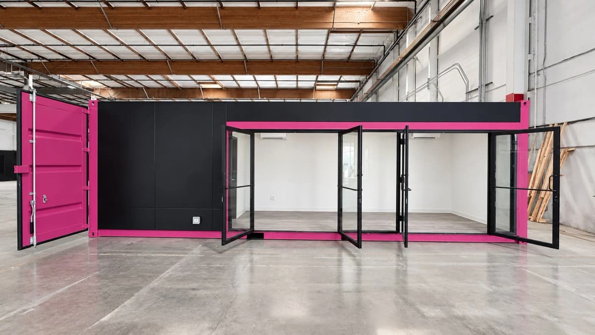 Pink 30ft Pulseworks container with black cladding and glass storefront