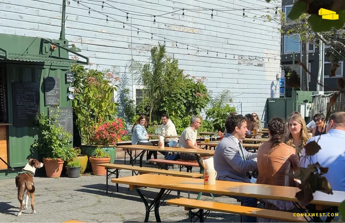 Outdoor picnic seating arranged near container units at Biergarten