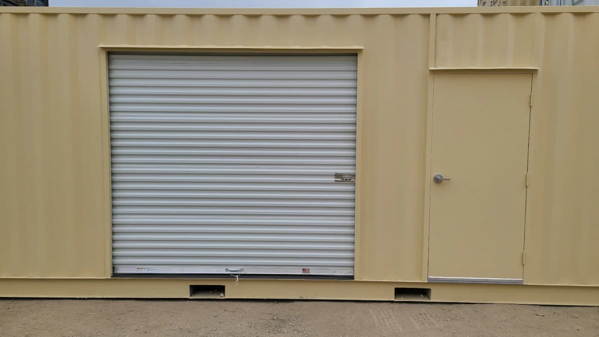 Front view of a storage container with a roll-up door and a man door beside it