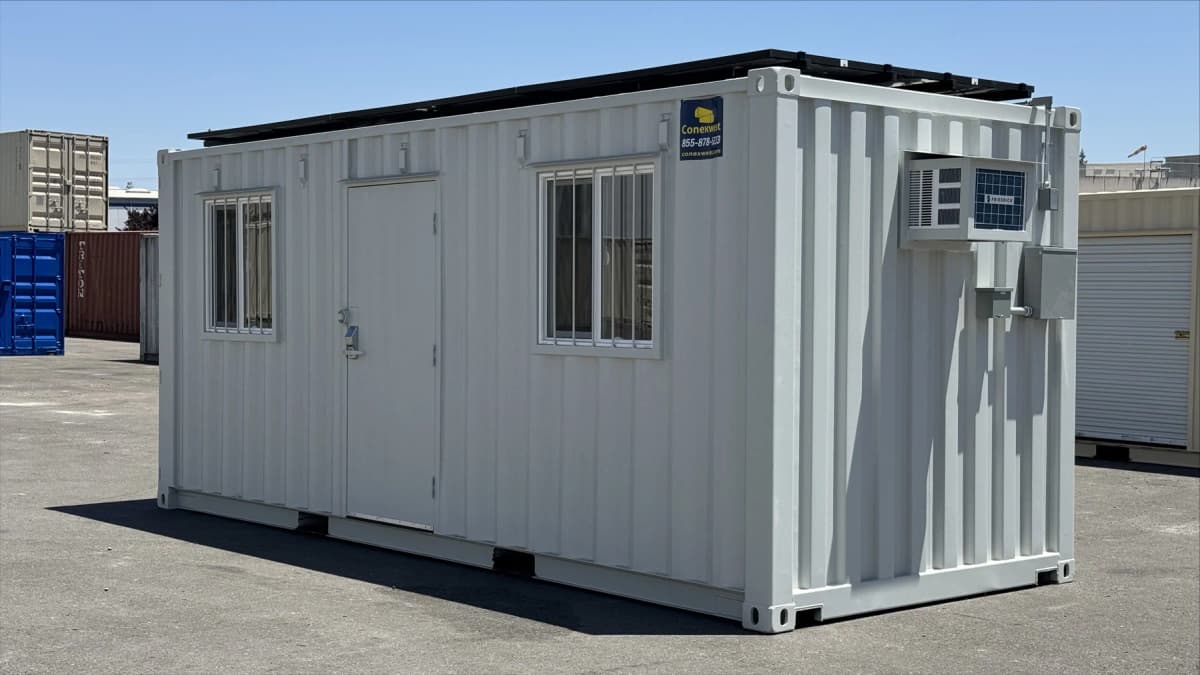 Solar-powered shipping container with roof-mounted panel array attached to a raised structural frame