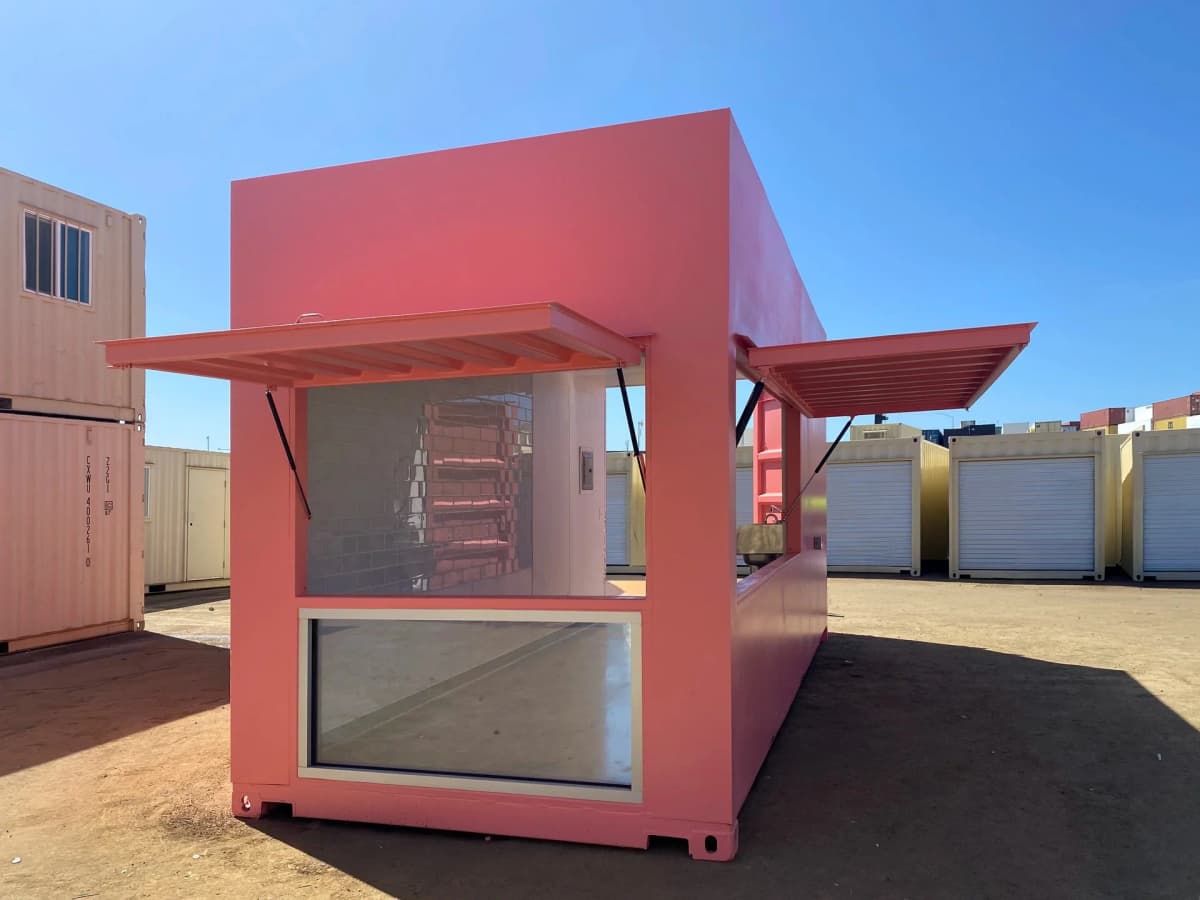 Interior of a 20ft custom storefront container with plumbing and white wall panels