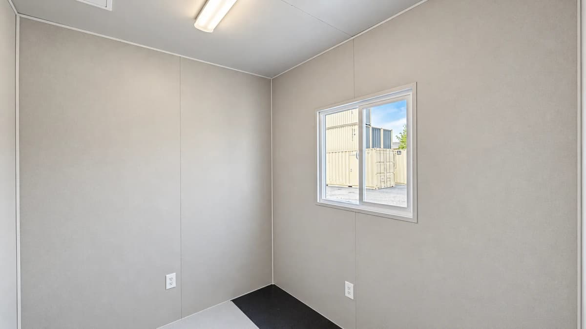 Finished private office area inside modified container with sliding window LED light fixture and electrical outlets