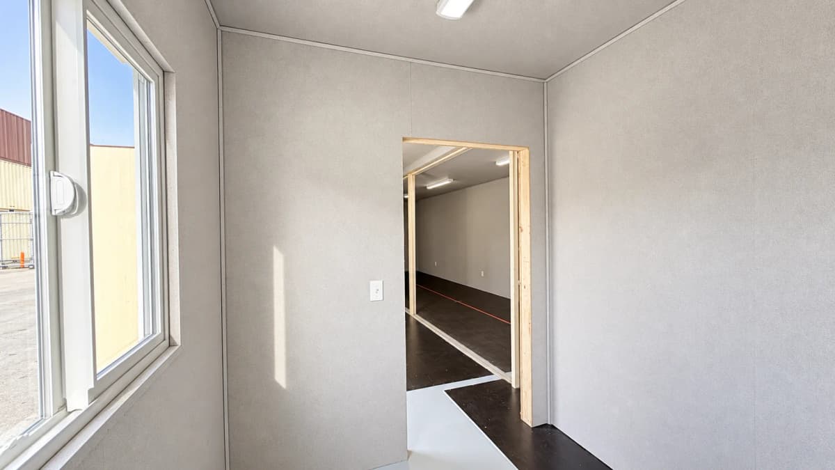 Private room inside Allied Environmental field office with sliding window electrical outlet and doorway leading to the main workspace