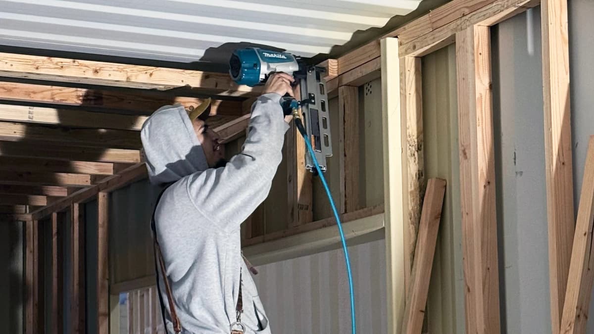 The worker is drilling the container