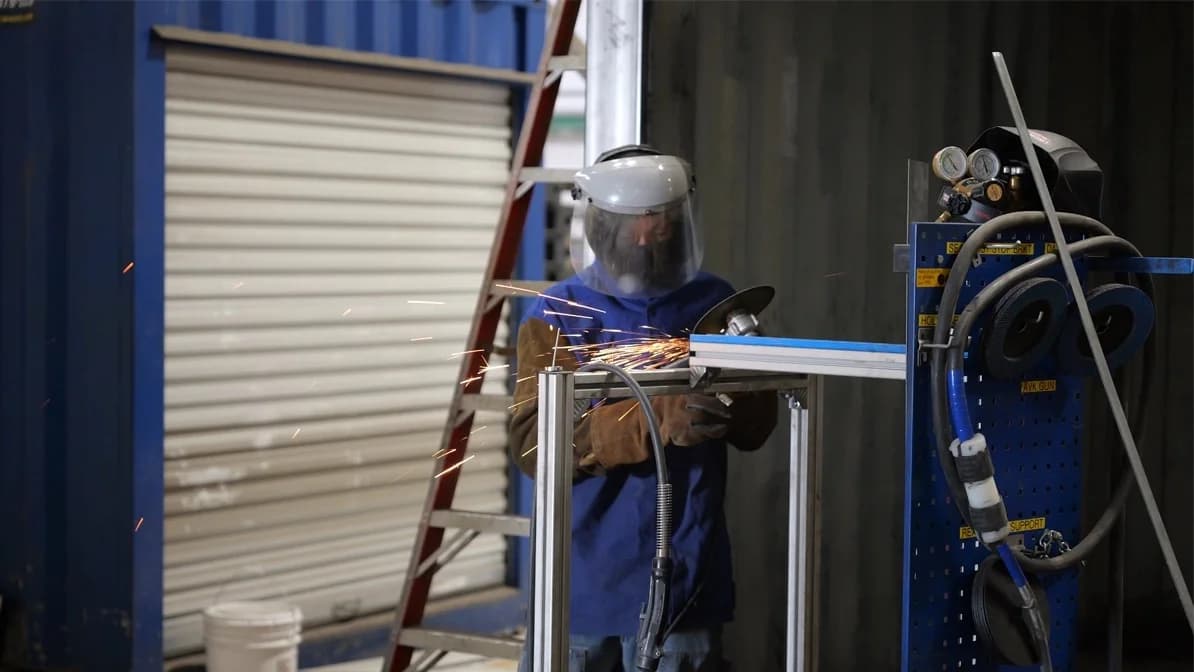 Worker installing roll-up door on container