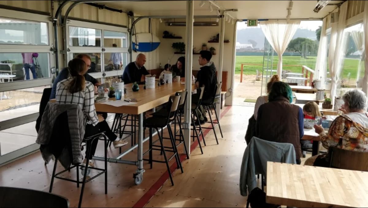 A group of people in a shipping container office.