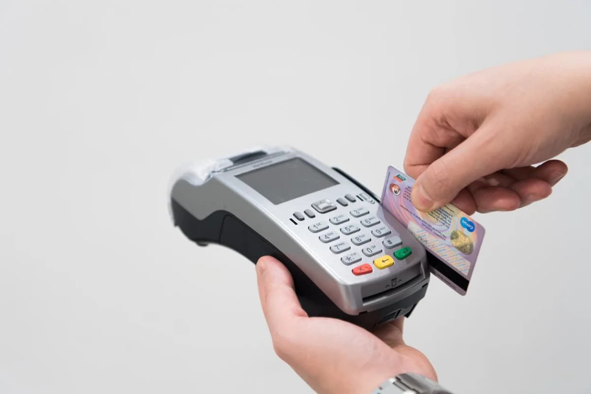 A person swiping their credit card in a card reader.