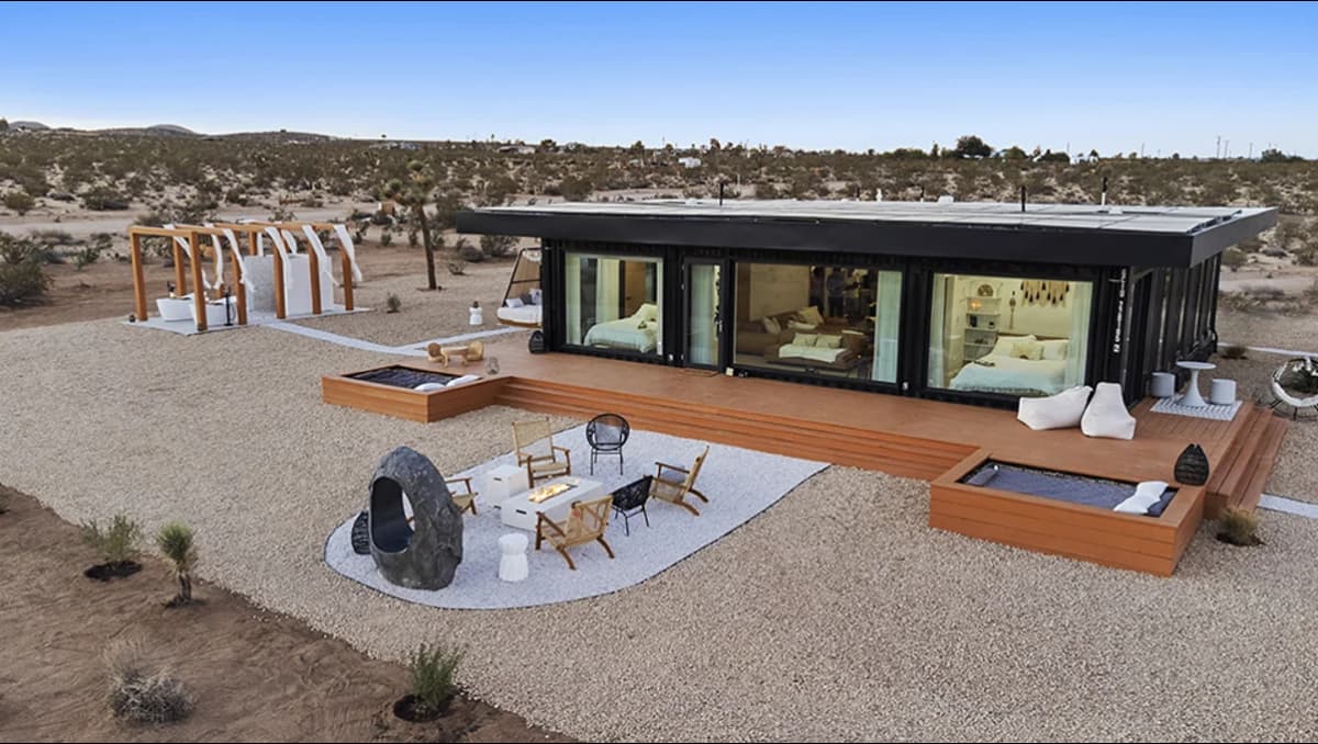 A shipping container home in a dry landscape with outdoor space.