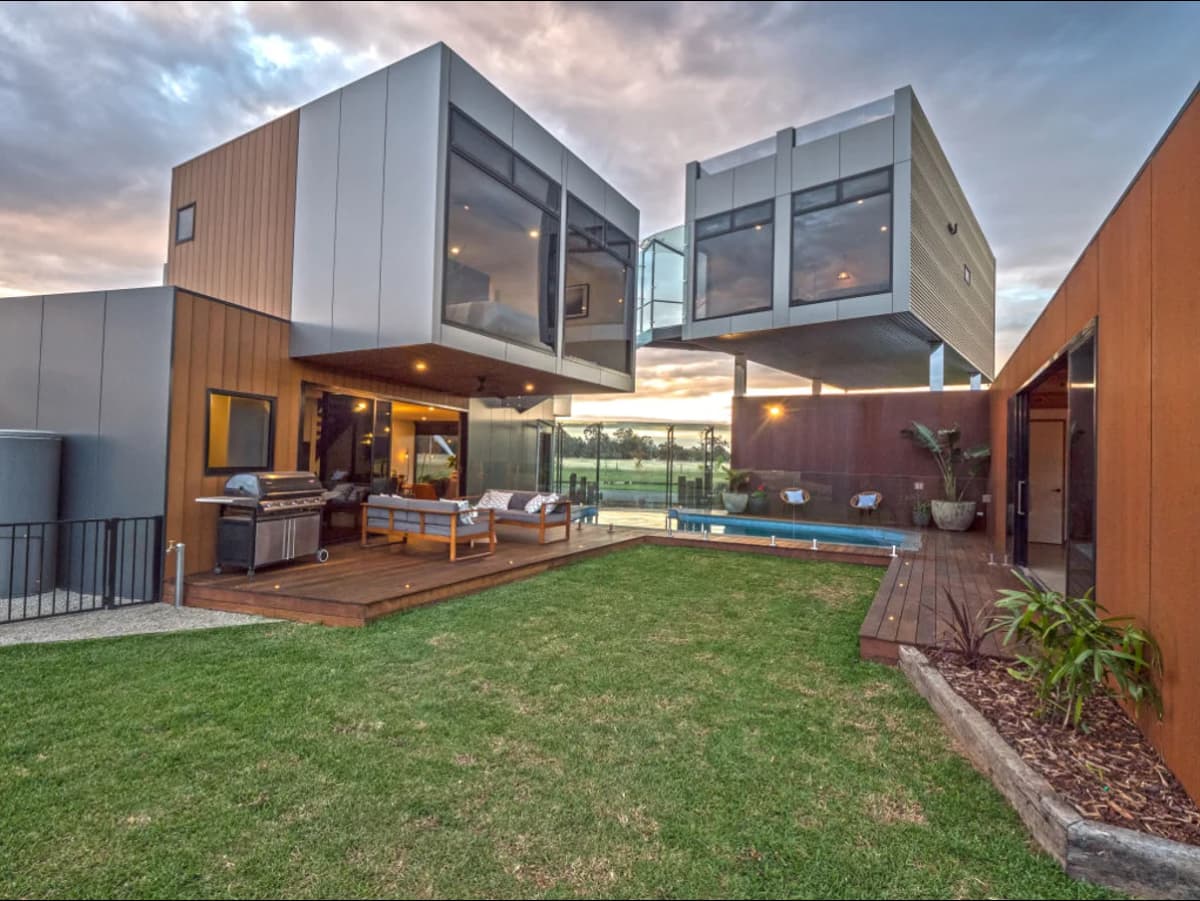 A modern shipping container home exterior with large windows and outdoor space.