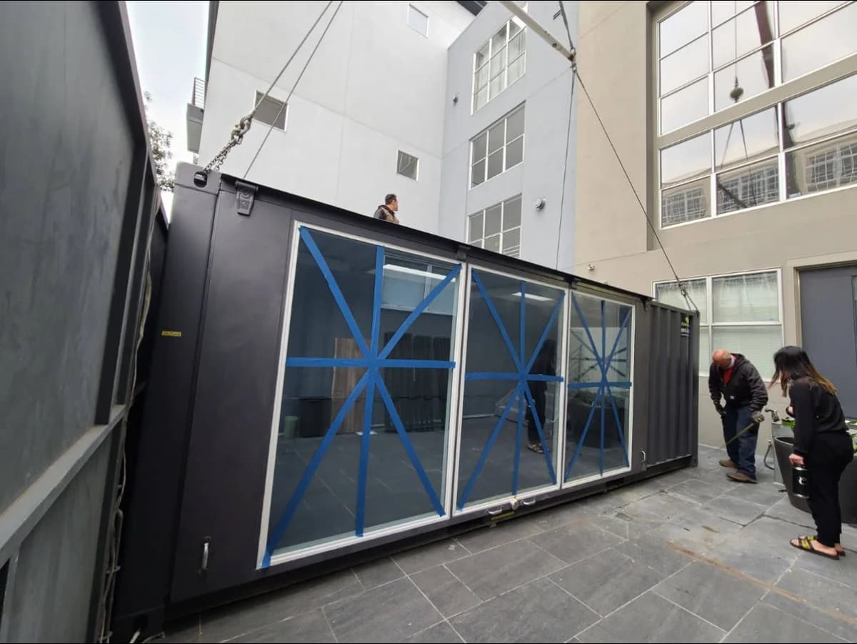 Conexwest team working on a shipping container structure.