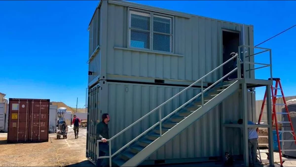 Image of a shipping container with an outdoor balcony.