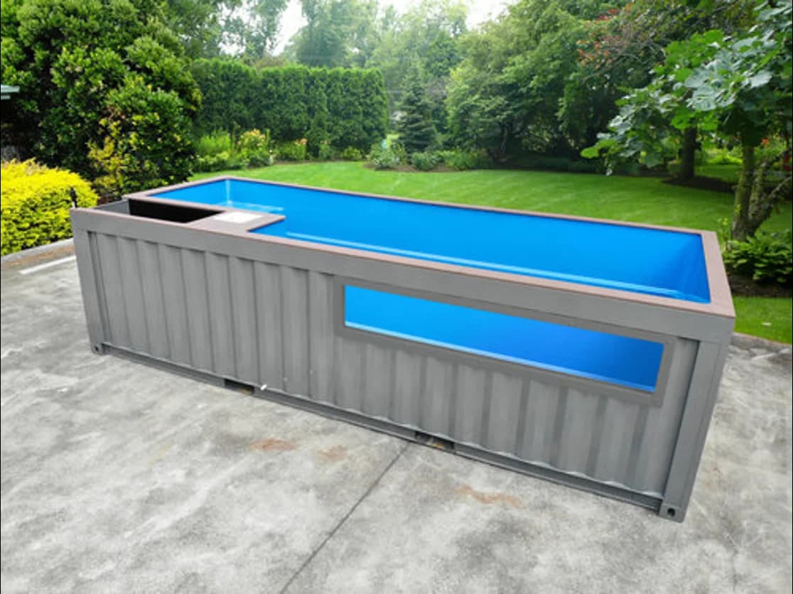 Rectangular shipping container pool with a built-in spa section and large viewing window on the side.