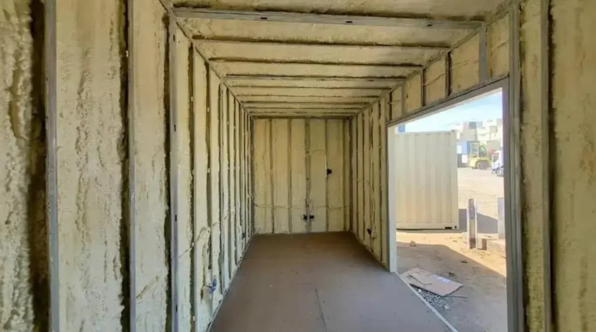 The interior of a container with the walls covered in spray foam insulation.