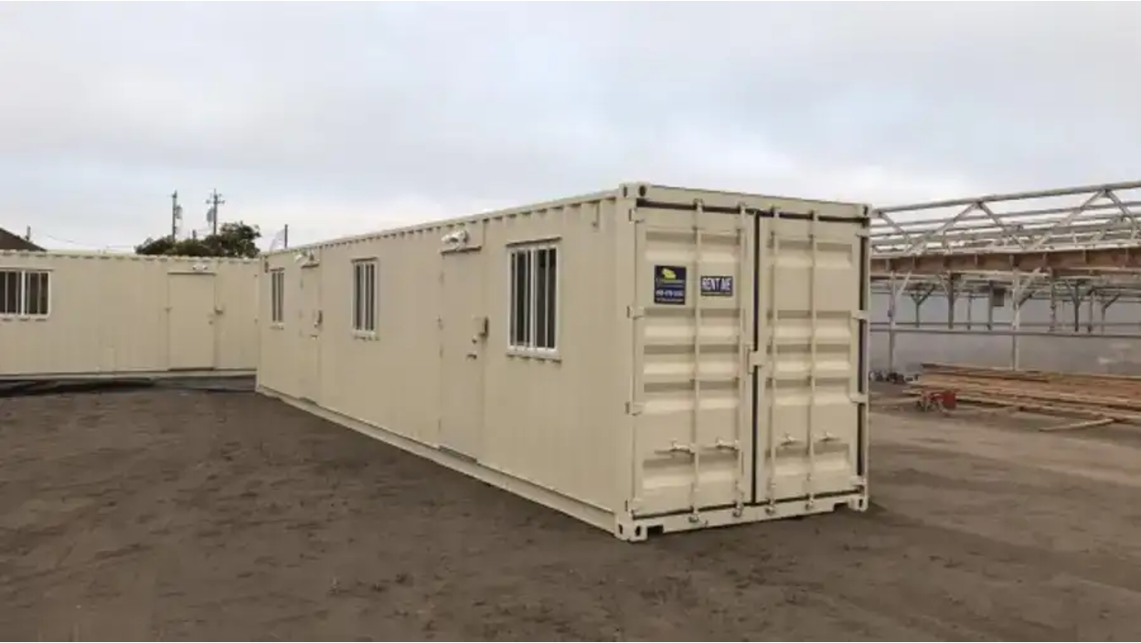 40-foot shipping container converted into a mobile office unit with multiple slide windows and air conditioning units.