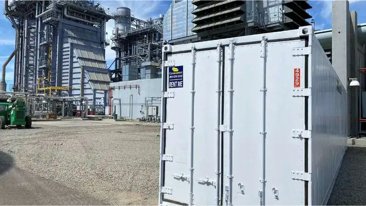 A gray shipping container in a lot