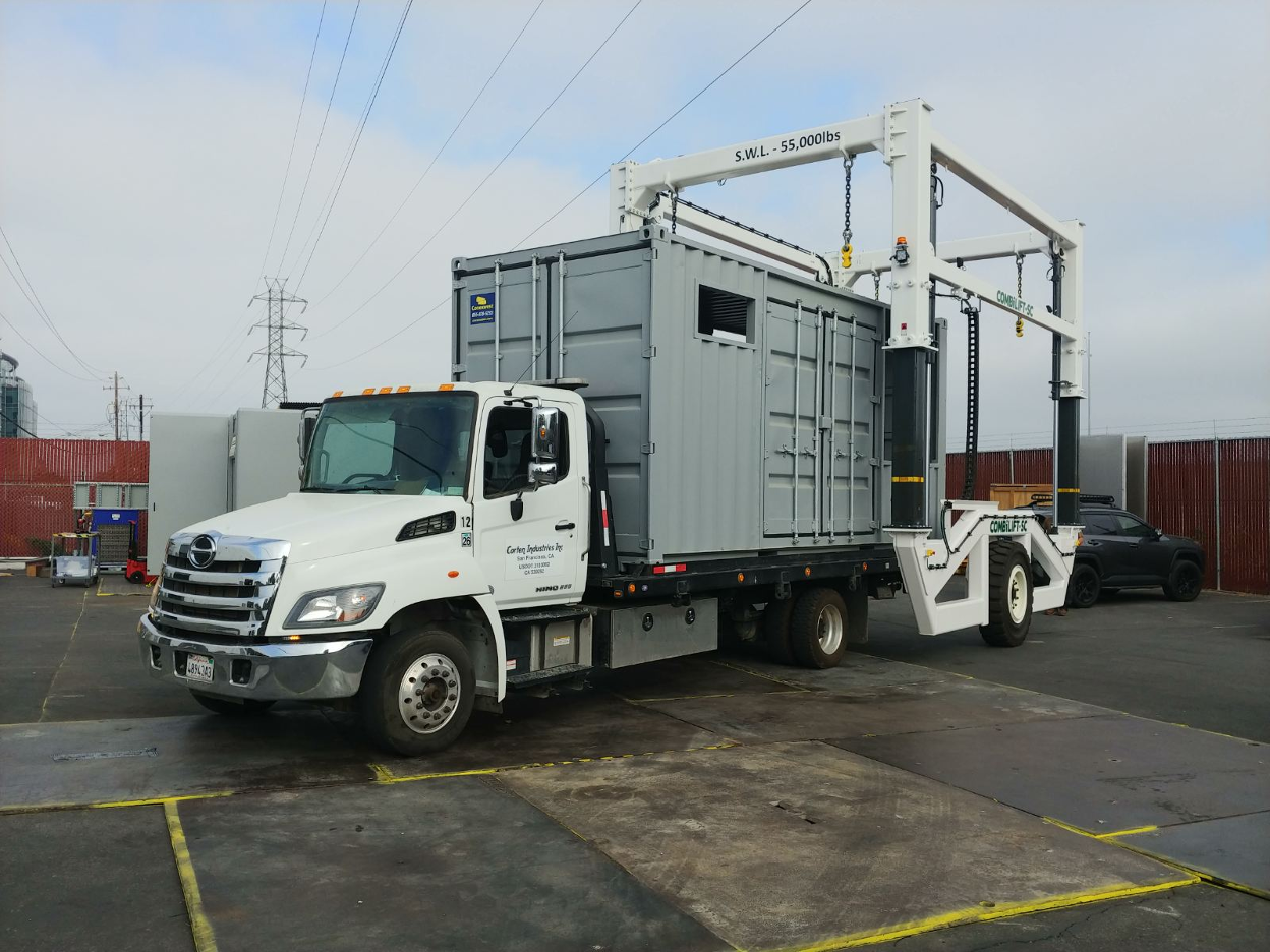 A heavy-duty white truck transporting a modified gray Conexwest shipping container.