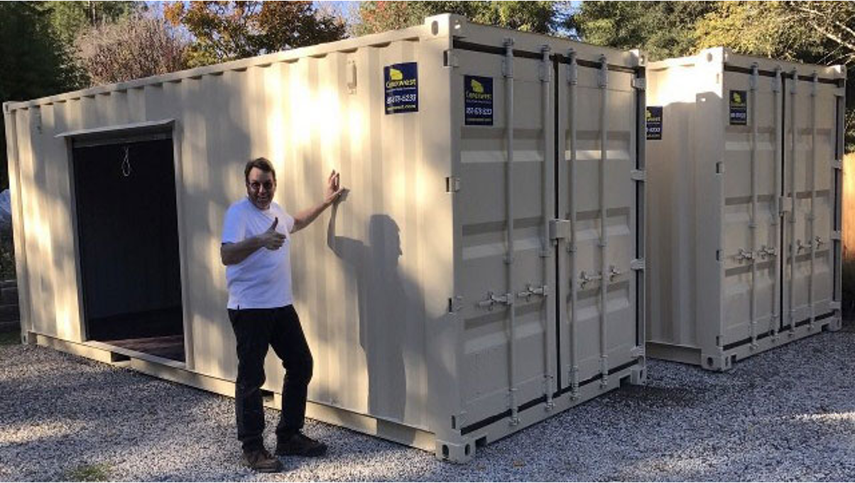 A man standing near a shipping container. 