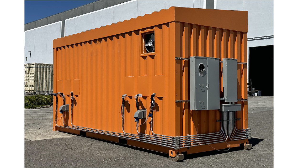 Orange shipping container with multiple electrical panels and ventilation fan installed.