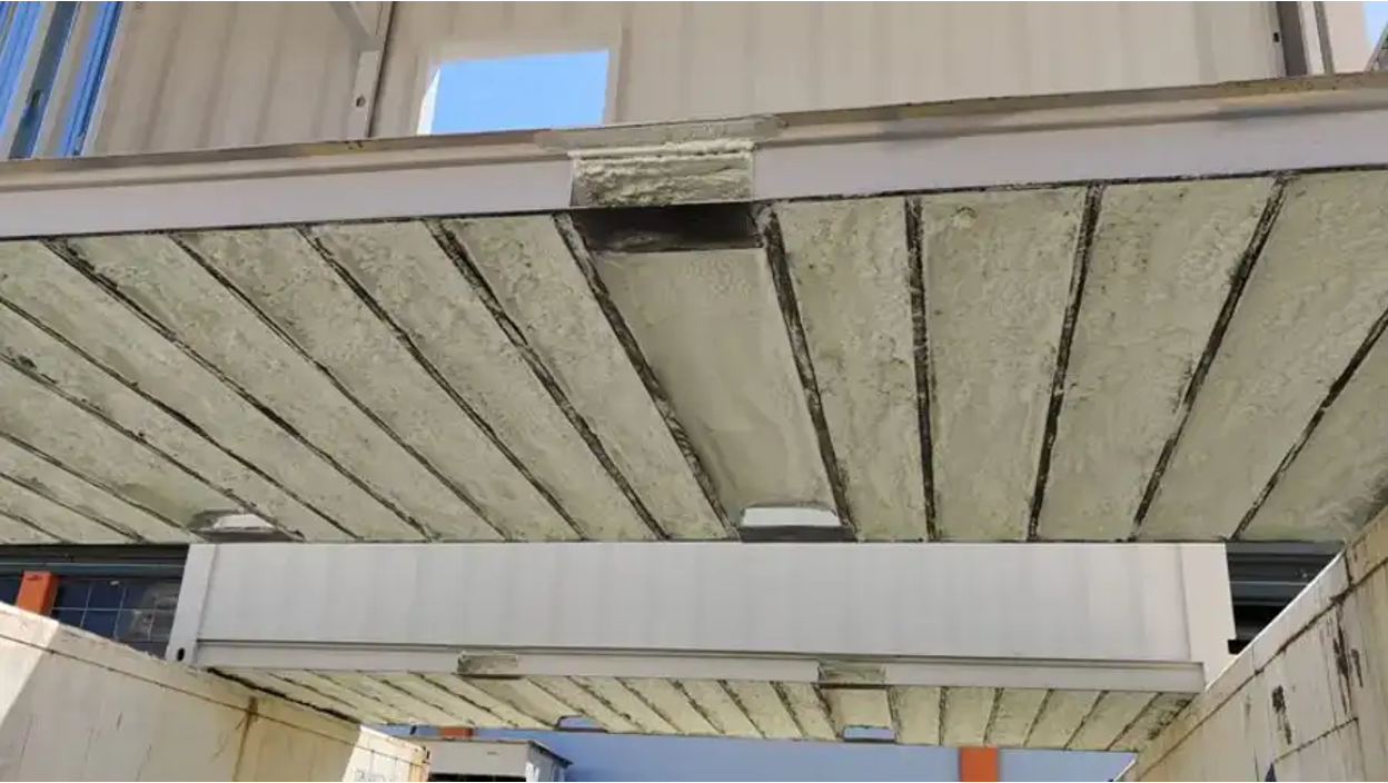 Spray foam insulation being applied to container walls