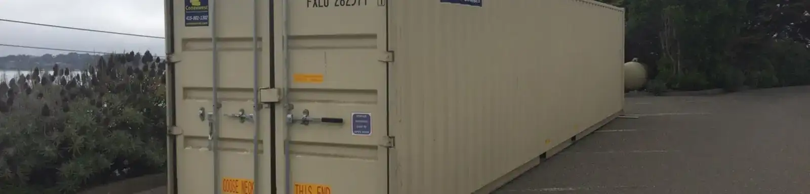 Shipping container on the side of the road with cargo doors